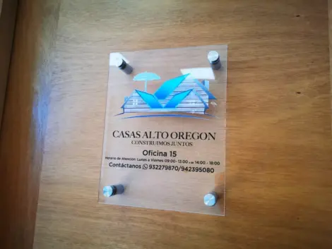 Letrero acrílico transparente instalado en puerta de acceso.